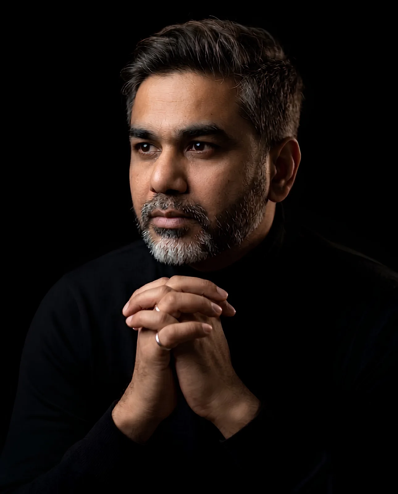 Aabhishek Siloya in a thoughtful, hands-clasped portrait.